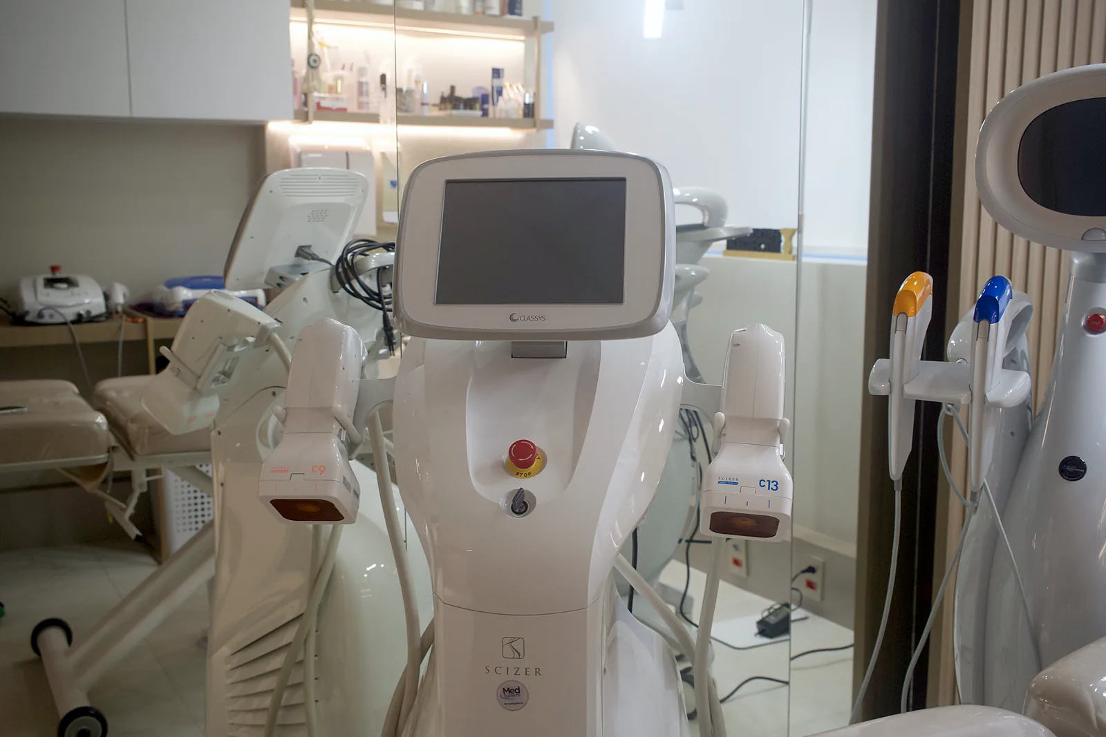 Equipamento Ultraformer MPT ao lado da maca na sala de atendimento da clínica.